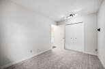 This spacious bedroom features plush carpeting and ample closet space, perfect for comfortable living.