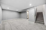Discover this beautifully finished basement, featuring plush grey carpeting throughout the spacious living area.
