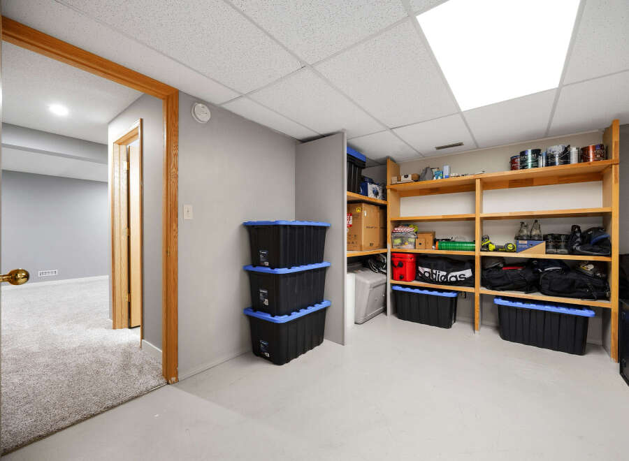 Discover ample storage solutions in this versatile space, featuring a wall of shelving stocked with various containers and supplies.