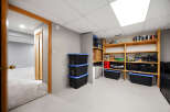 Discover ample storage solutions in this versatile space, featuring a wall of shelving stocked with various containers and supplies.