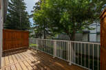 Enjoy outdoor living on this spacious wooden deck, complete with a white railing for safety and style.