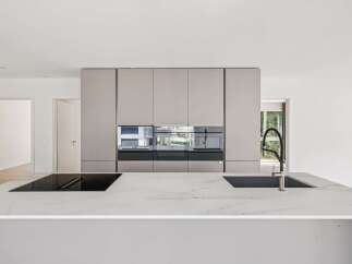 Experience modern luxury in this stunning kitchen, featuring sleek, integrated cabinetry and a spacious marble island.
