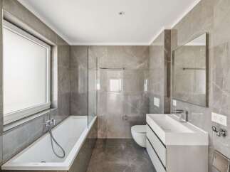 Experience modern luxury in this stunning bathroom featuring elegant grey marble tiles throughout.