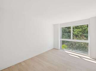 Experience modern living in this bright and airy room, featuring a large window that floods the space with natural light.