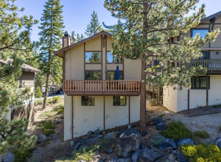 Nestled amidst tall pine trees, this charming mountain home offers a serene retreat with its multi-level design and spacious wooden deck perfect for enjoying the crisp alpine air.