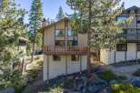 Nestled amidst tall pine trees, this charming mountain home offers a serene retreat with its multi-level design and spacious wooden deck perfect for enjoying the crisp alpine air.
