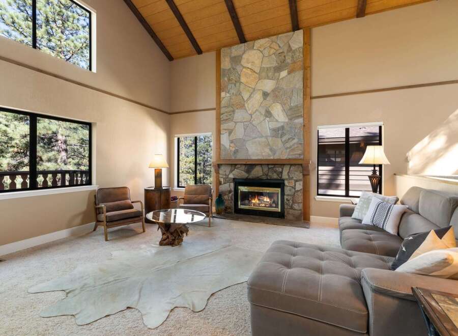 Experience rustic charm in this spacious living room featuring a grand stone fireplace as the centerpiece.