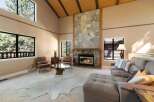 Experience rustic charm in this spacious living room featuring a grand stone fireplace as the centerpiece.