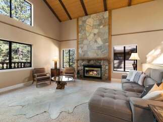 Experience rustic charm in this spacious living room featuring a grand stone fireplace as the centerpiece.