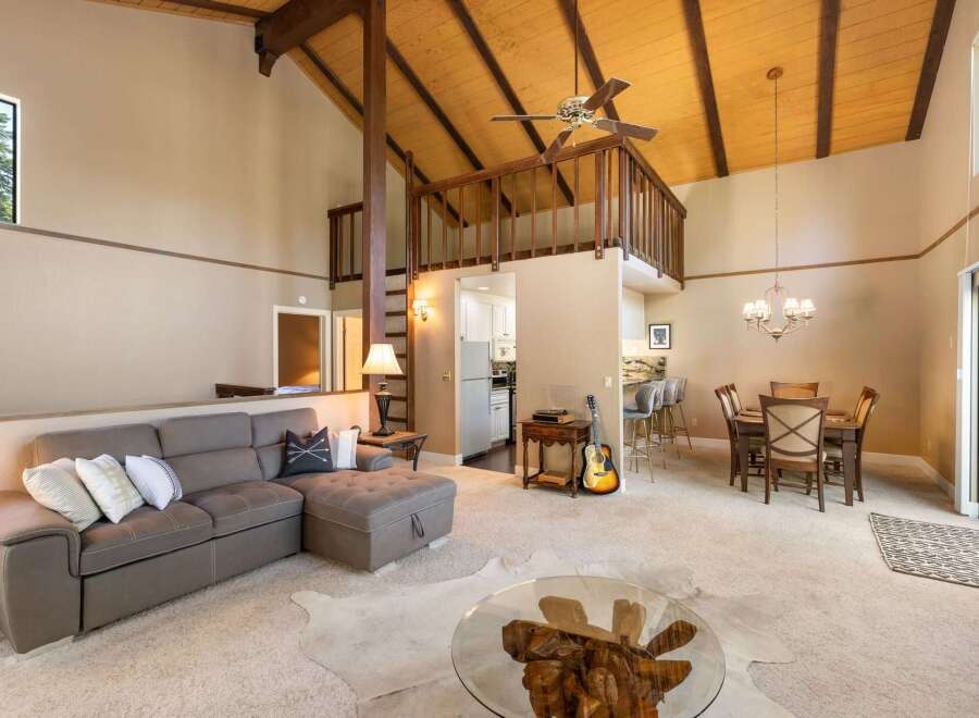 Experience the charm of this inviting living space, featuring a spacious sectional sofa perfect for relaxation and a cozy dining area for intimate meals.