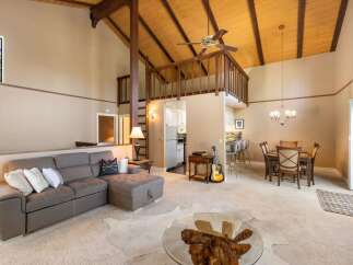 Experience the charm of this inviting living space, featuring a spacious sectional sofa perfect for relaxation and a cozy dining area for intimate meals.