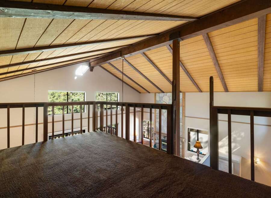 Experience the unique charm of this loft space, featuring a vaulted wood-paneled ceiling with exposed beams that create a warm, rustic ambiance.