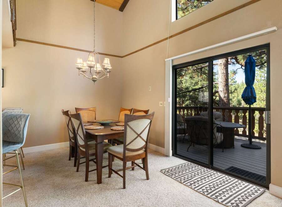Experience comfortable dining in this inviting space, featuring a charming chandelier and a spacious dining table set for six.