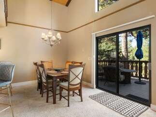 Experience comfortable dining in this inviting space, featuring a charming chandelier and a spacious dining table set for six.