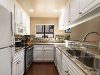 Discover this charming kitchen featuring pristine white cabinetry and elegant granite countertops.