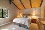 Experience cozy comfort in this charming bedroom, featuring a plush white comforter and a rustic wooden headboard.