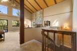 Experience breathtaking views from this stunning home featuring a dramatic vaulted ceiling with exposed wood beams and a striking stone fireplace.