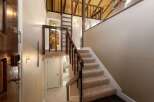 Step into this charming home featuring a welcoming entryway with a wooden door and a convenient staircase leading to the upper level.