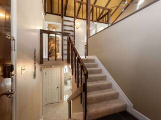Step into this charming home featuring a welcoming entryway with a wooden door and a convenient staircase leading to the upper level.