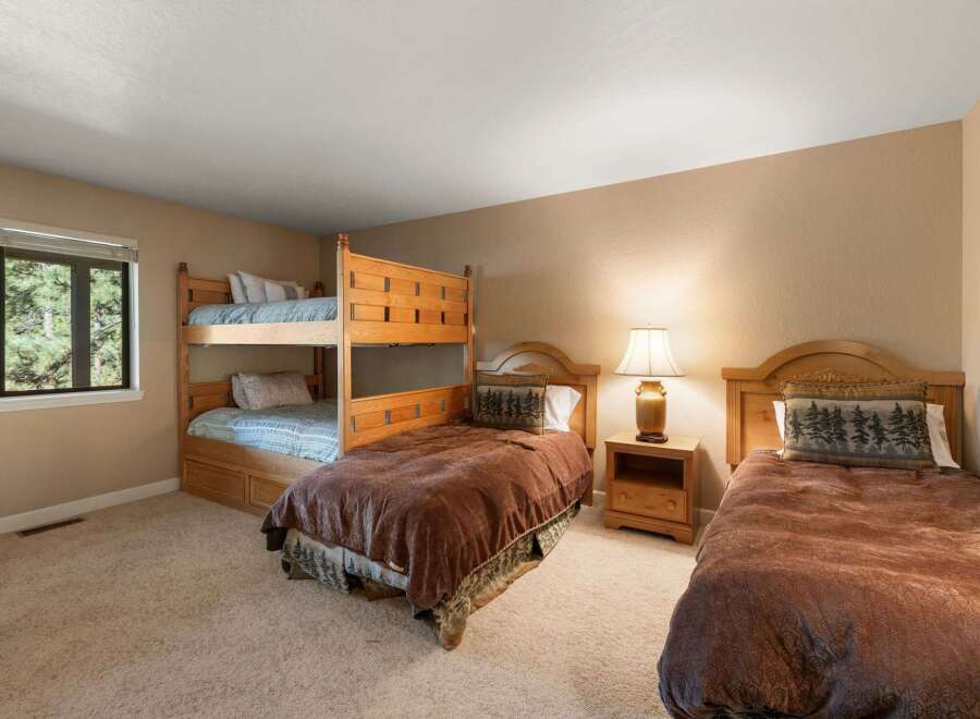 This charming bedroom offers comfortable sleeping arrangements with a sturdy wooden bunk bed and a separate twin bed, perfect for families or groups.