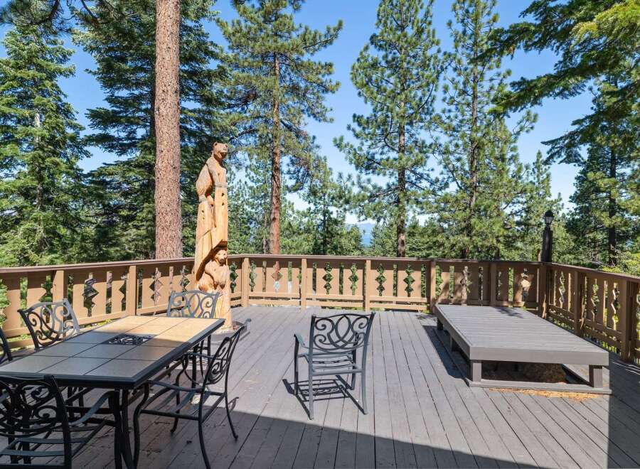 Enjoy breathtaking views from this expansive wooden deck, perfect for outdoor entertaining or quiet relaxation.