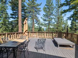 Enjoy breathtaking views from this expansive wooden deck, perfect for outdoor entertaining or quiet relaxation.