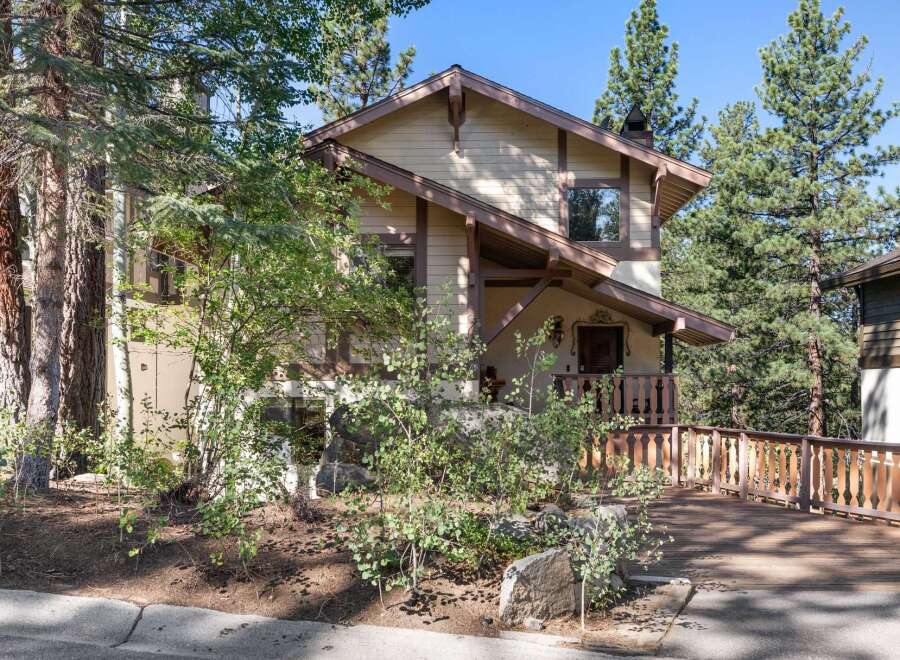 Nestled amidst tall pine trees, this charming home offers a rustic mountain retreat.