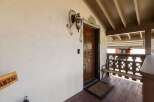 Welcome guests to this charming property with a beautifully carved wooden front door, adorned with decorative floral artwork and a classic lantern.