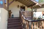 Welcome to this charming cabin, featuring a rustic wooden bear statue and a decorative lantern on the porch.