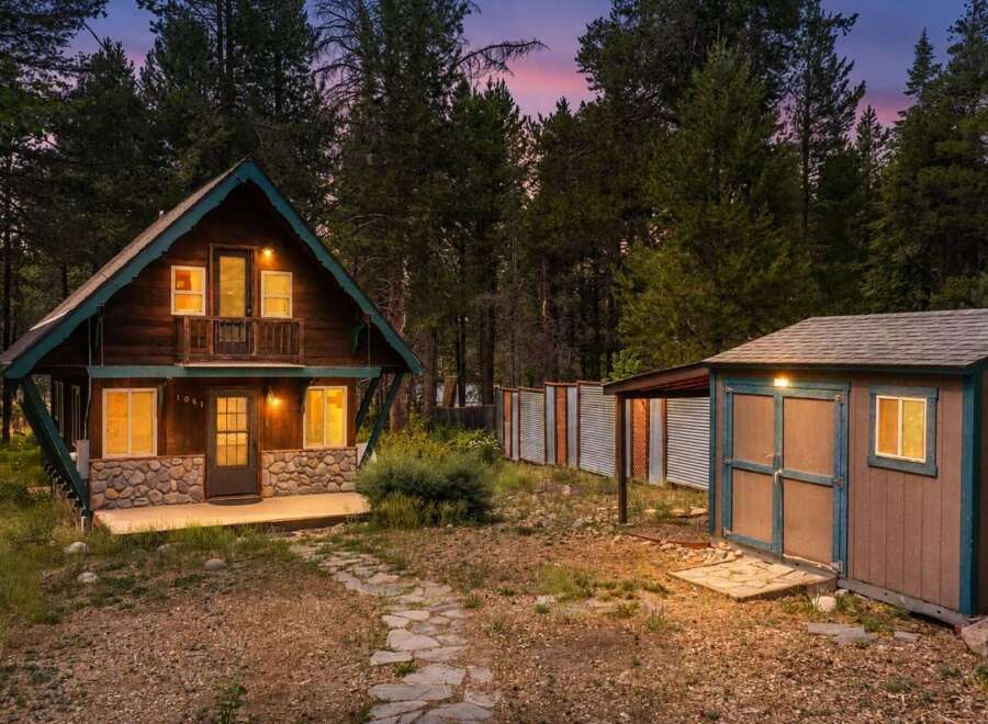 Nestled amidst tall pine trees, this charming rustic cabin offers a serene mountain retreat.