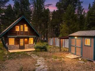 Nestled amidst tall pine trees, this charming rustic cabin offers a serene mountain retreat.