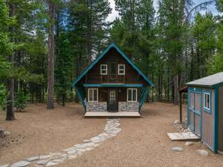 Escape to this charming A-frame cabin nestled amongst tall pine trees, offering a serene mountain retreat.