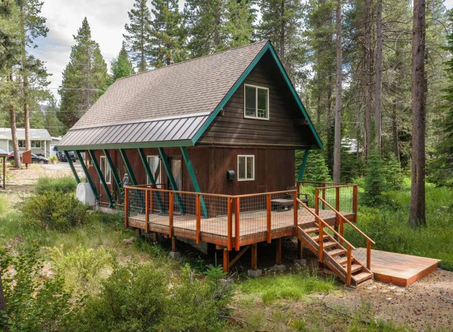 Nestled amongst tall pine trees, this charming cabin offers a serene mountain retreat.