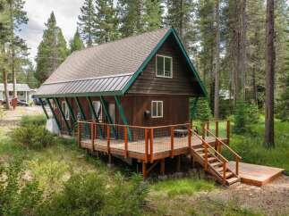 Nestled amongst tall pine trees, this charming cabin offers a serene mountain retreat.
