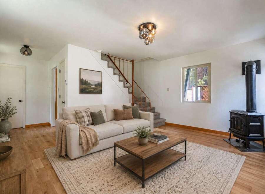 Cozy living room featuring a comfortable sofa, a rustic coffee table, and a charming wood-burning stove for warmth.