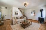 Cozy living room featuring a comfortable sofa, a rustic coffee table, and a charming wood-burning stove for warmth.