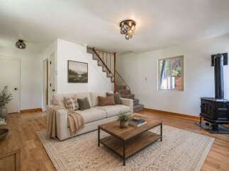Cozy living room featuring a comfortable sofa, a rustic coffee table, and a charming wood-burning stove for warmth.
