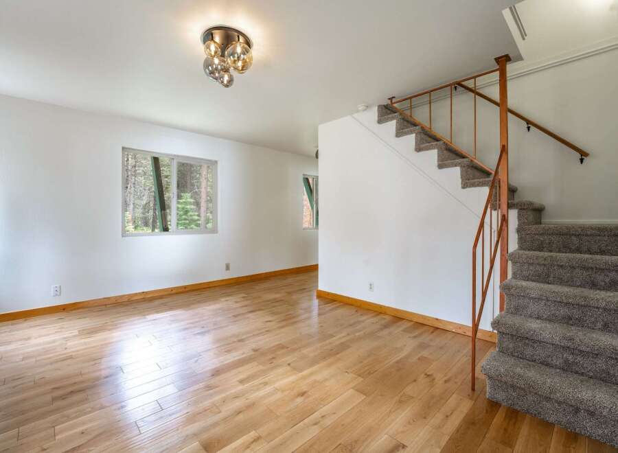 Step into this inviting living space featuring gleaming hardwood floors and abundant natural light from the large windows.