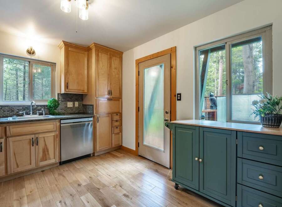 Discover this charming kitchen featuring light wood cabinetry and a sleek stainless steel dishwasher.