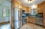 Discover this charming kitchen featuring light wood cabinetry and a sleek stainless steel refrigerator.