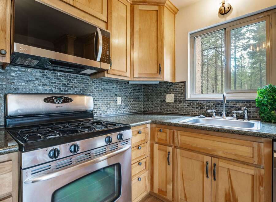 Discover this charming kitchen featuring a sleek stainless steel gas range and a modern microwave oven.