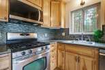 Discover this charming kitchen featuring a sleek stainless steel gas range and a modern microwave oven.