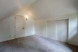 Discover this charming attic bedroom, featuring a vaulted ceiling and ample natural light.