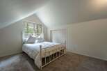 This charming bedroom features a cozy white metal bed adorned with plush pillows, perfect for restful nights.
