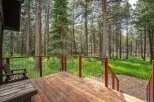 Enjoy the serene mountain lifestyle from this charming deck, nestled amongst towering pine trees.