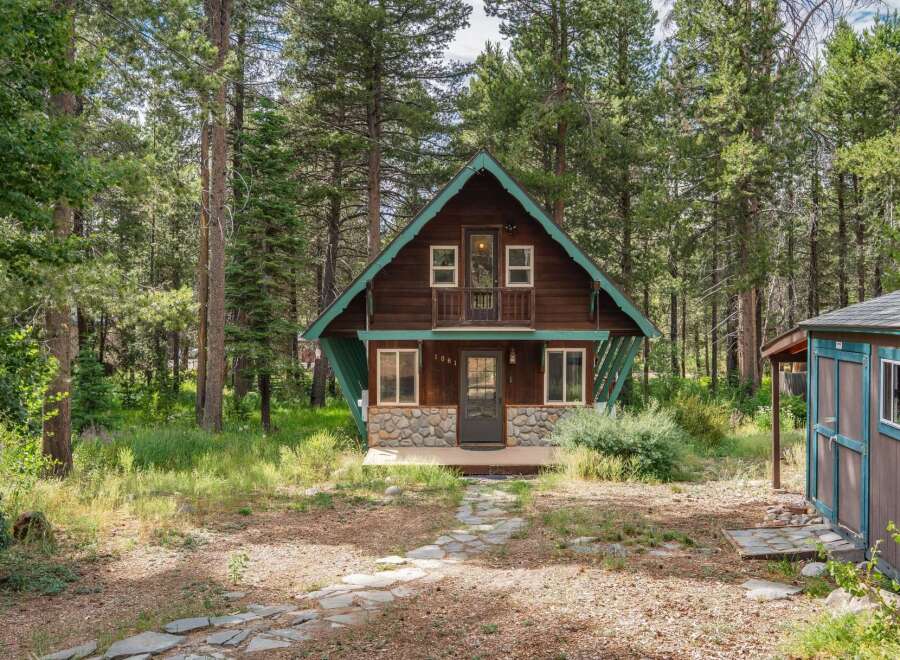 Nestled amidst tall pine trees, this charming rustic cabin offers a serene getaway.