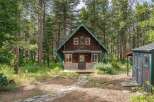 Nestled amidst tall pine trees, this charming rustic cabin offers a serene getaway.