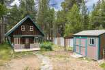 Charming rustic cabin nestled among tall pine trees, offering a serene mountain getaway.