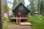 Escape to this charming cabin nestled among tall pine trees, offering a serene mountain getaway.