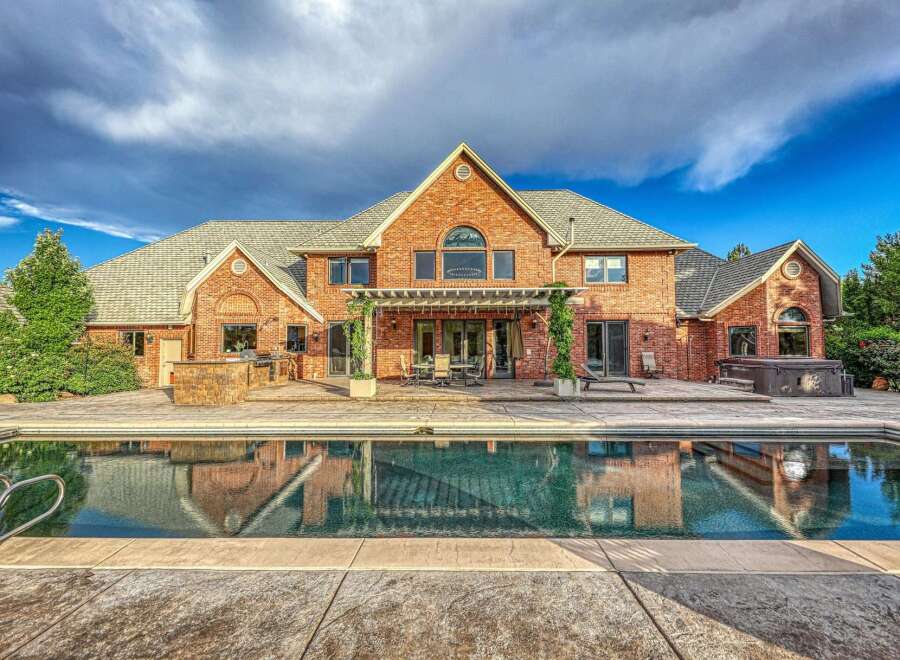 Experience luxury outdoor living with this stunning backyard featuring a sparkling swimming pool and a relaxing hot tub.